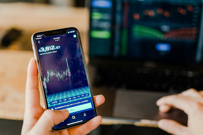 Une personne consulte ses placements sur son ordinateur portable et sur son téléphone