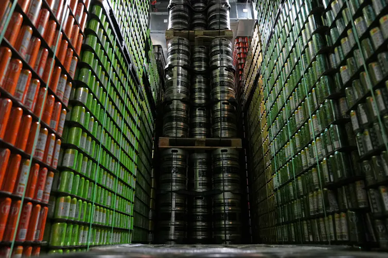 Cans and kegs of craft beer are stacked on top of one another in a warehouse
