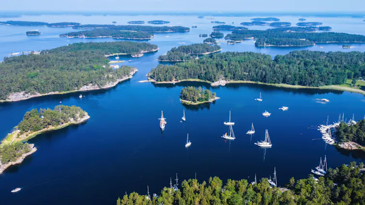 aerial view of island chain and assembled yachts off the coast of stockholm, sweden.