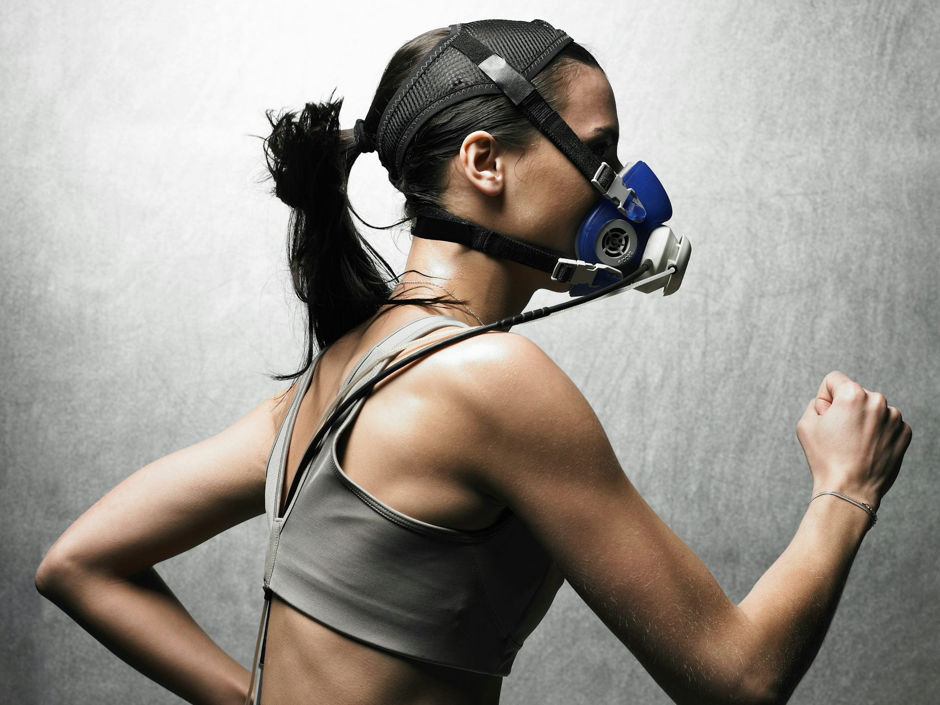 A woman wearing sensors and breathing mask running