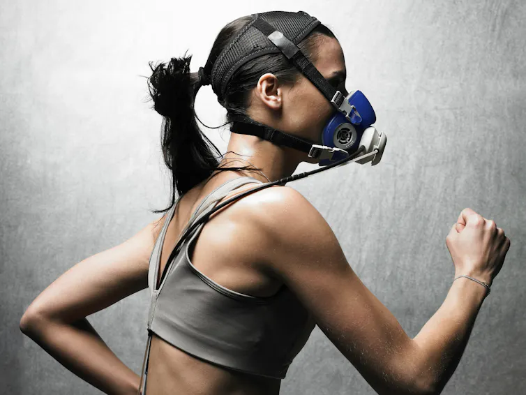 A woman wearing sensors and breathing mask running