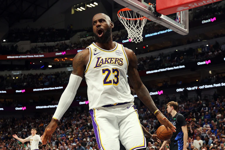 LeBron James celebrating in mid-air with arena crowd in background