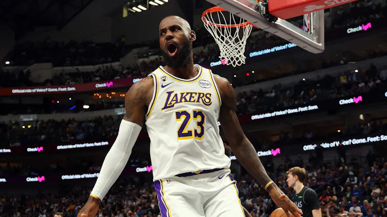 LeBron James celebrating in mid-air with arena crowd in background