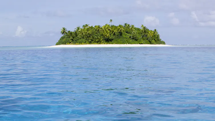 A low-lying Pacific island in Tuvalu surrounded by blue sea.