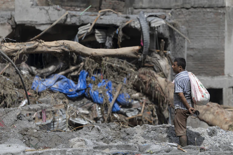 A man stares at a damaged dwelling in Nepal after a devastating flash flood.