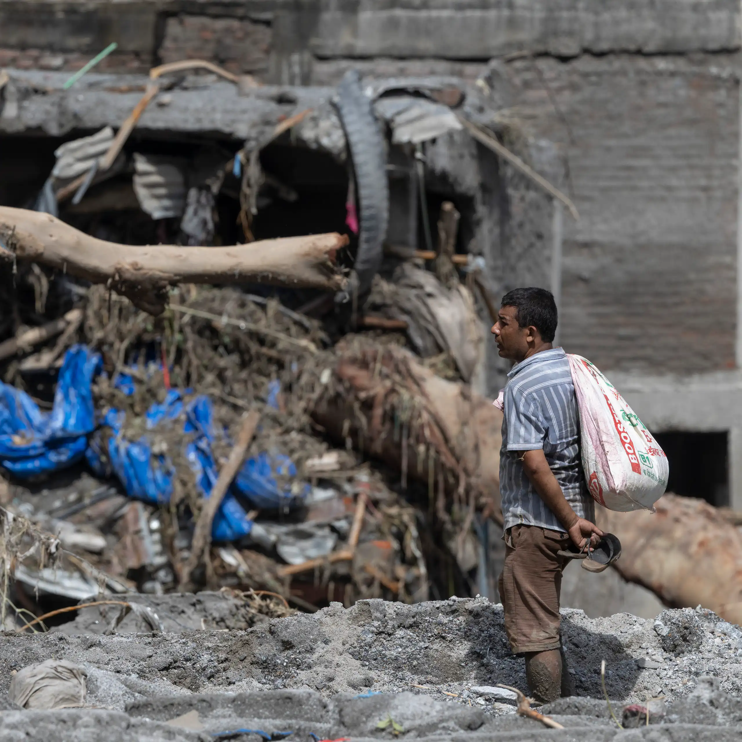 A man stares at a damaged dwelling in Nepal after a devastating flash flood.