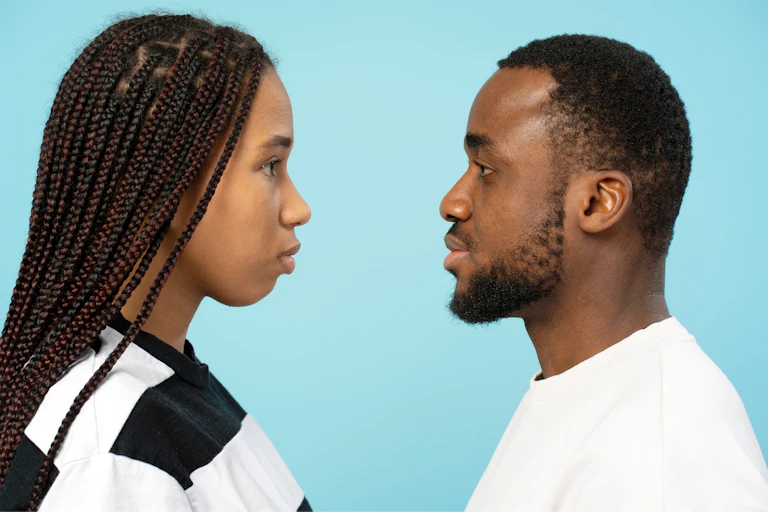 A woman and a man stare into each other's eyes.