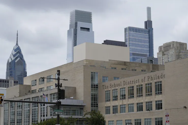 View of building with letters that say 'School District of Philadelphia' and skyscrapers behind it