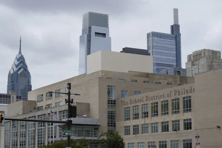 View of building with letters that say 'School District of Philadelphia' and skyscrapers behind it