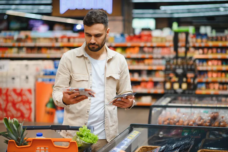 Man choosing between two products in a supermarket