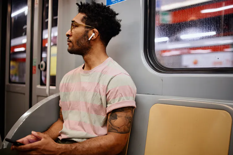 man on subway wearing earbuds