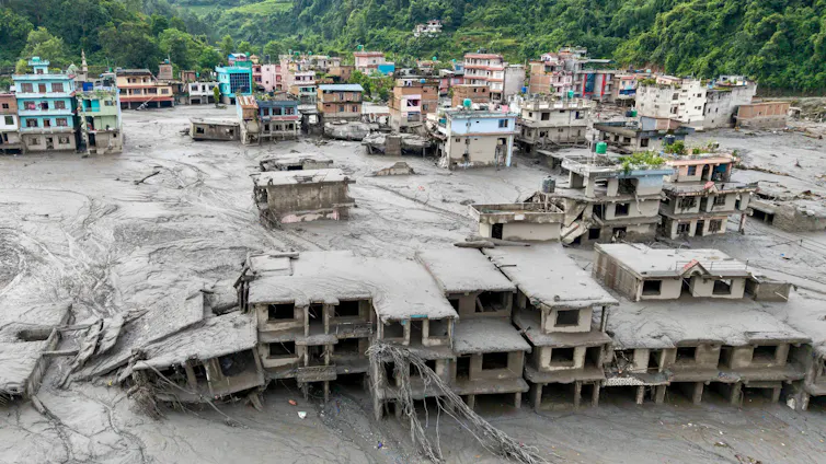 Houses covered in mud, several blocks from a river.