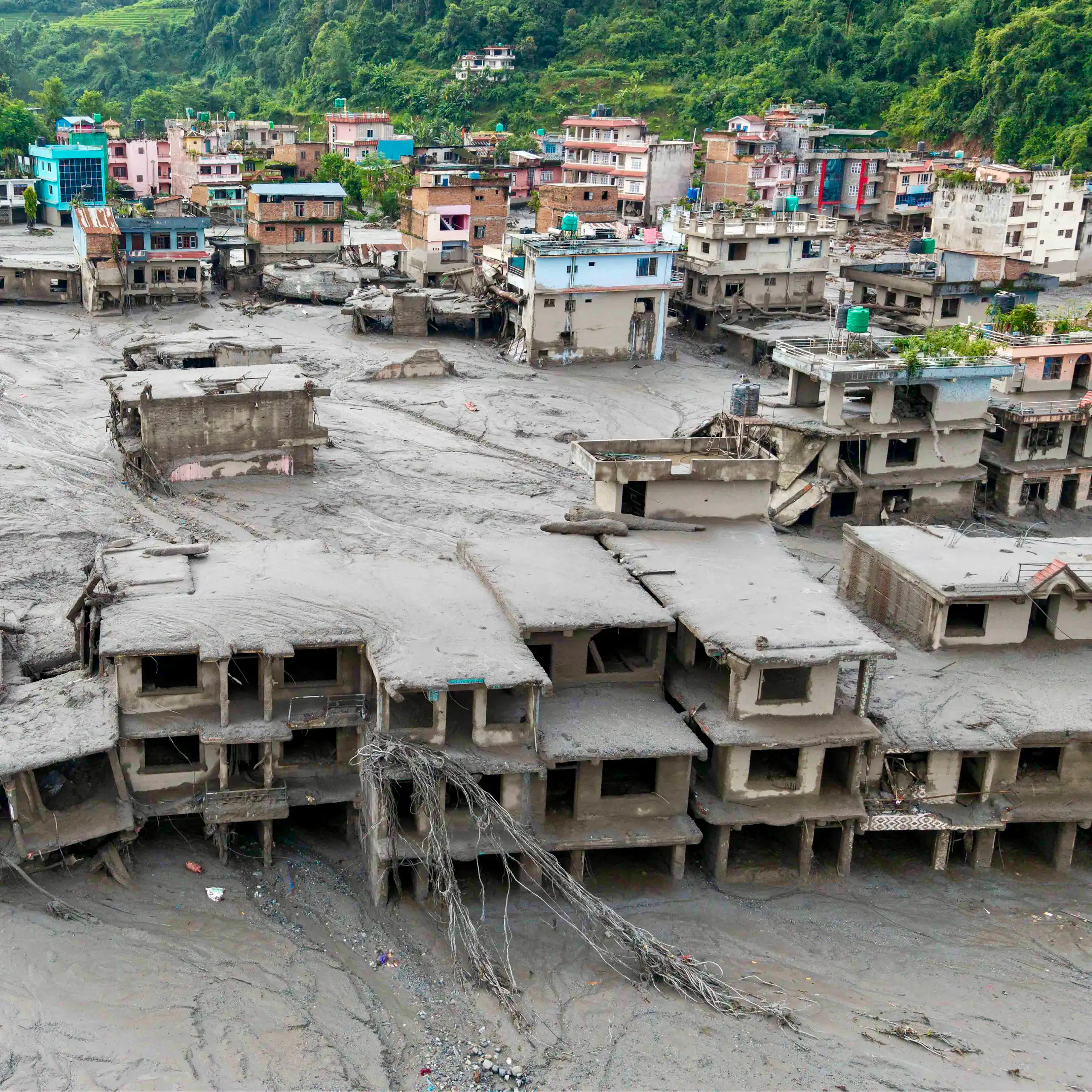 Houses covered in mud, several blocks from a river.