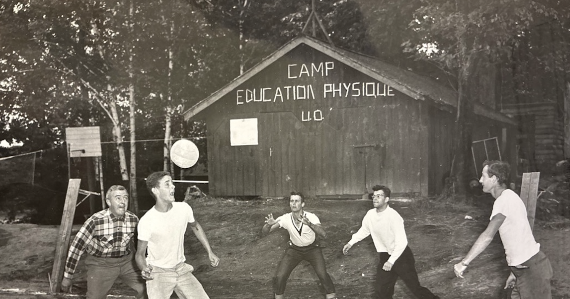Photo en noir et blanc d'un groupe d'hommes jouant au volleyball