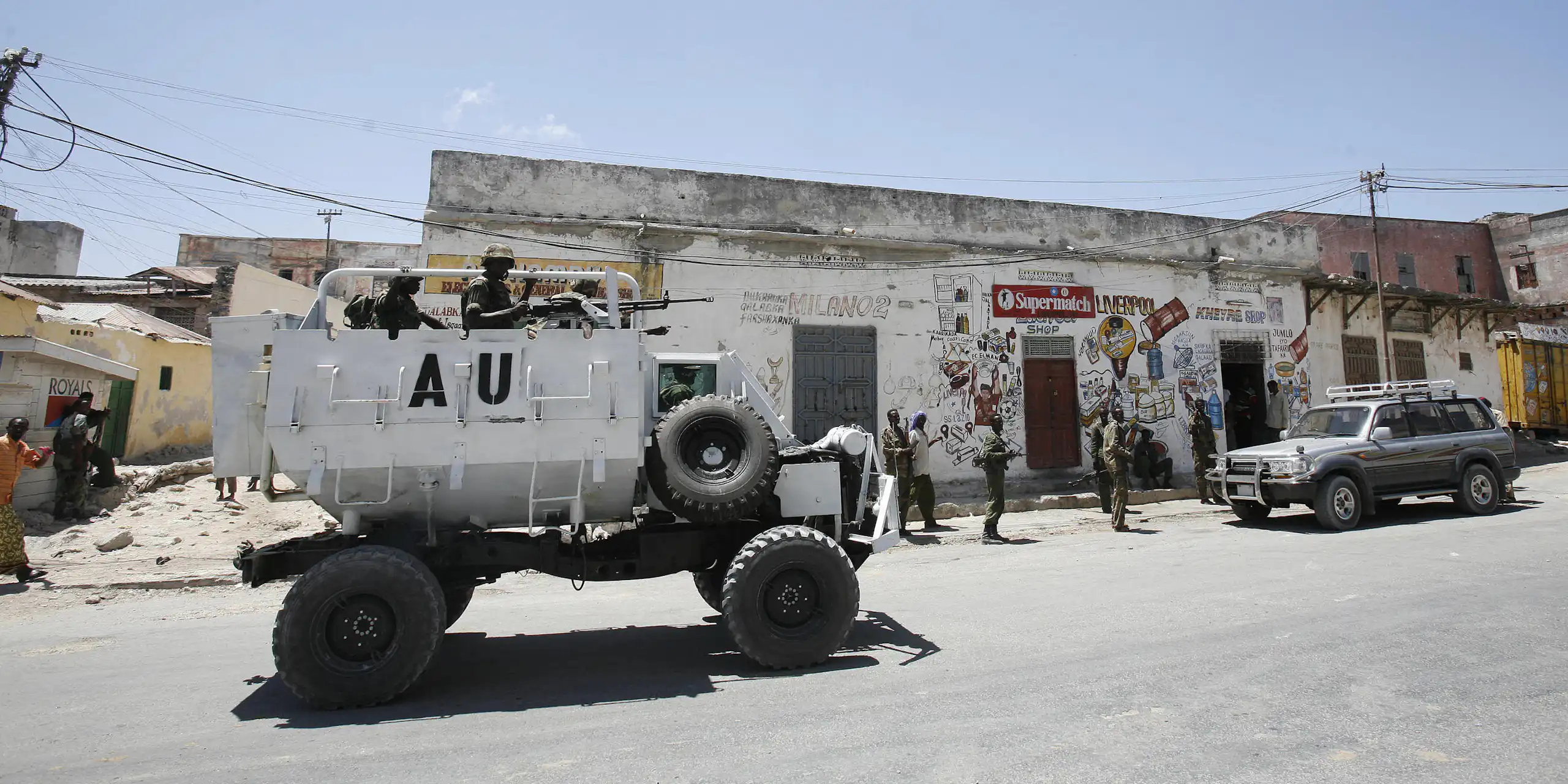 Armed people in a white vehicle with AU on its side, in a street