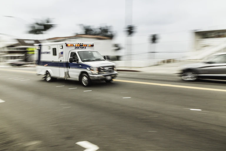 Blurred motion shot of ambulance speeding down the road.