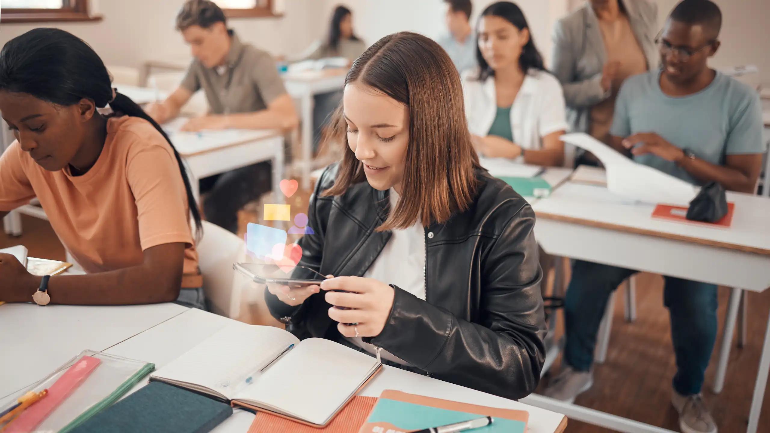 Una alumna mira el mòbil a classe.