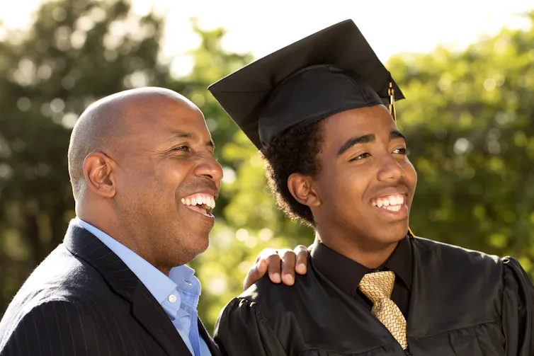 proud dad and his graduate son wearing mortar board.