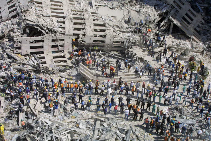 Aerial view of the wreckage of the World Trade Center, crowds of first responders attempting to rescue and recover survivors from the rubble