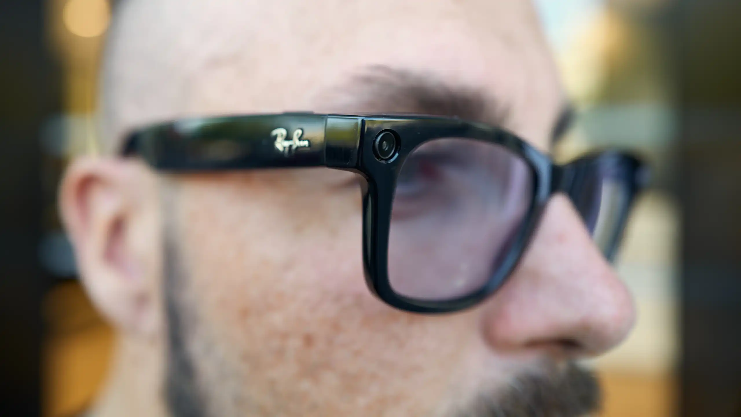 A close up of a man wearing Ray Ban Meta smart glasses, which can be used for recording