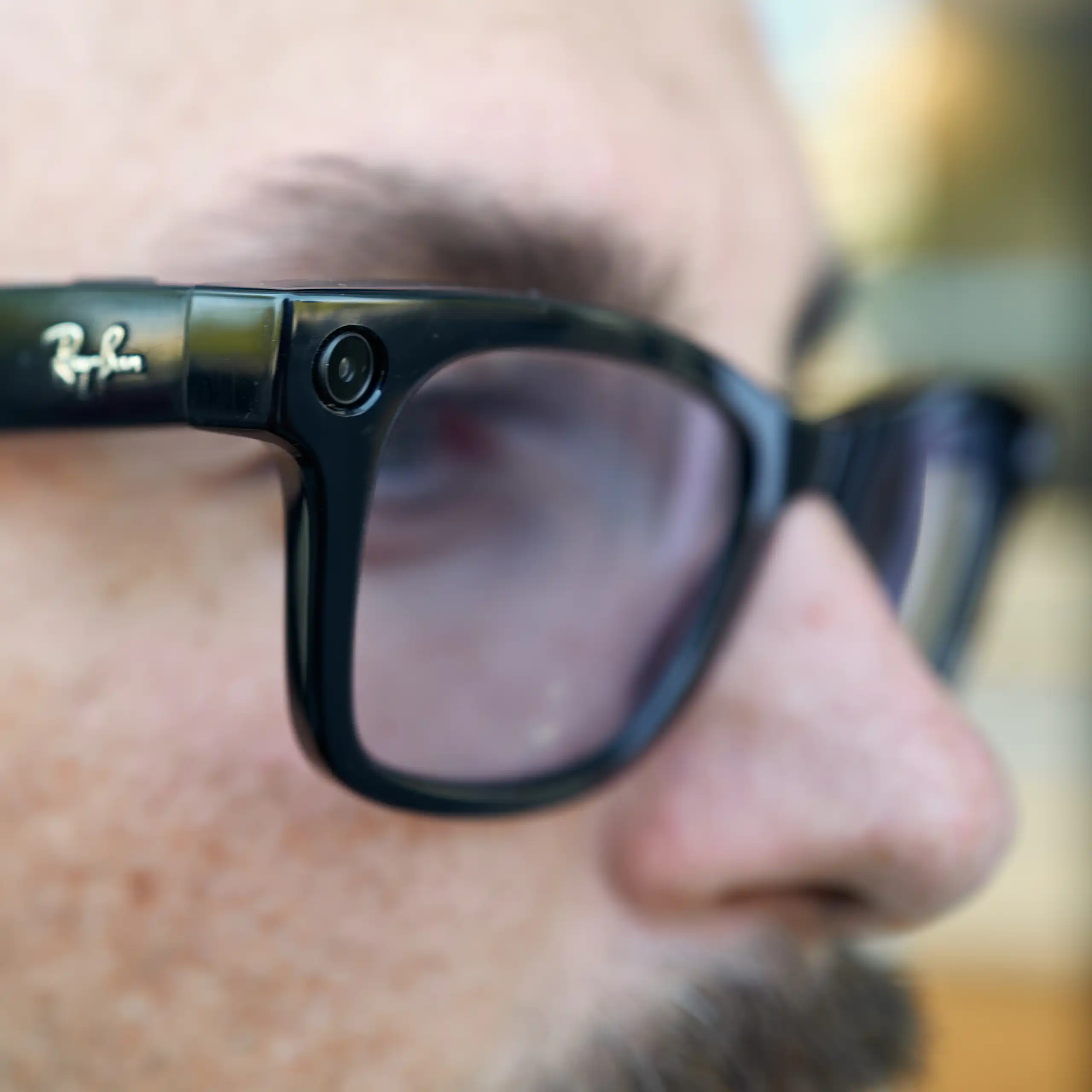 A close up of a man wearing Ray Ban Meta smart glasses, which can be used for recording