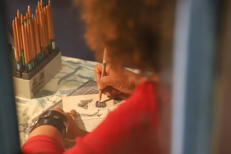 A woman creates a collage.