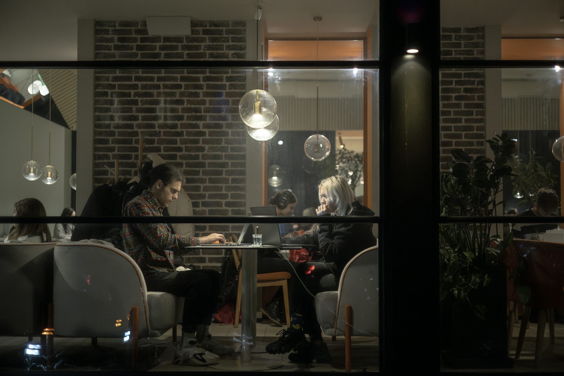 People working on their laptops in a cafe in Kyiv.