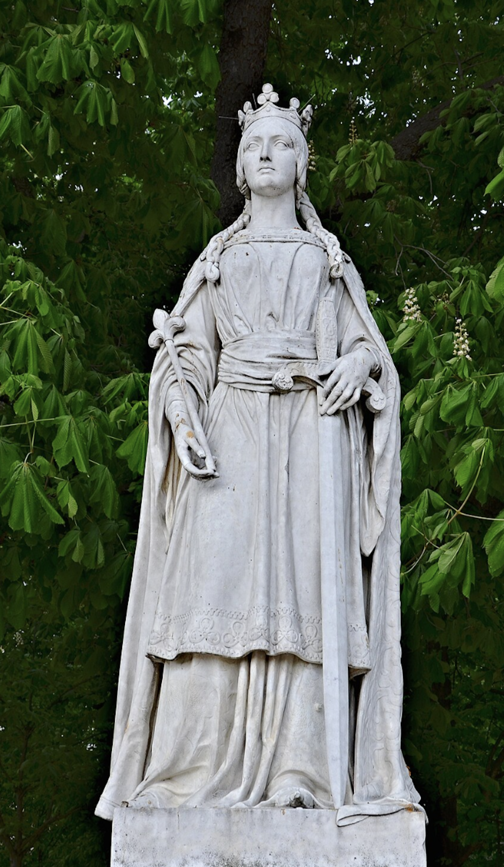 A marble statue of Matilda of Flanders with foliage in the background.