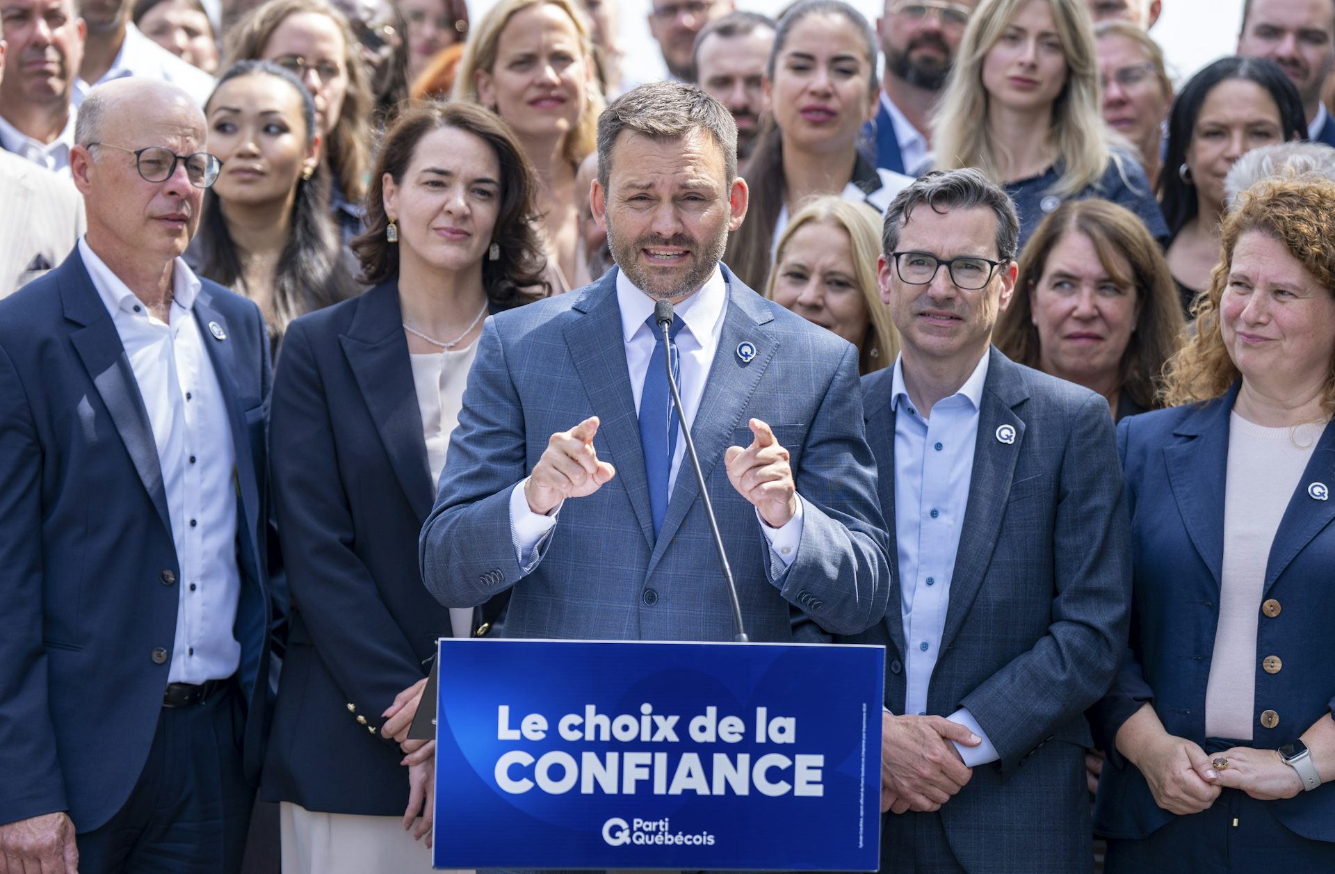 Paul St-Pierre Plamondon en train de parler dans un micro, entouré de nombreuses personnes