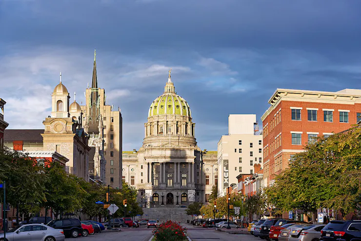 A large, ornate building sits at the end of a busy street.