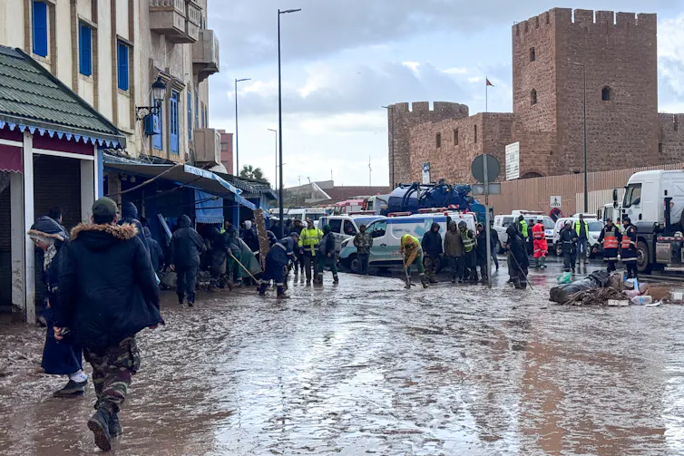 a muddy wet street in an urban area near an old fort.
