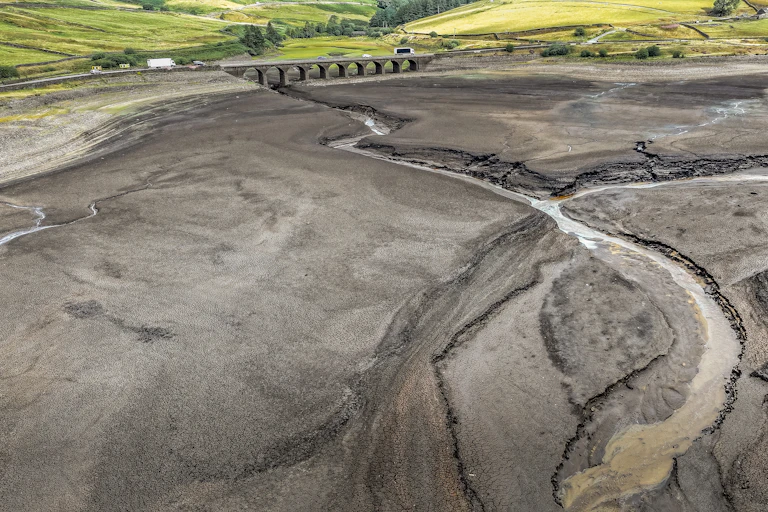 dry reservoir and small stream entering it, aerial view