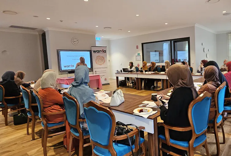 Women sit around a workshop.