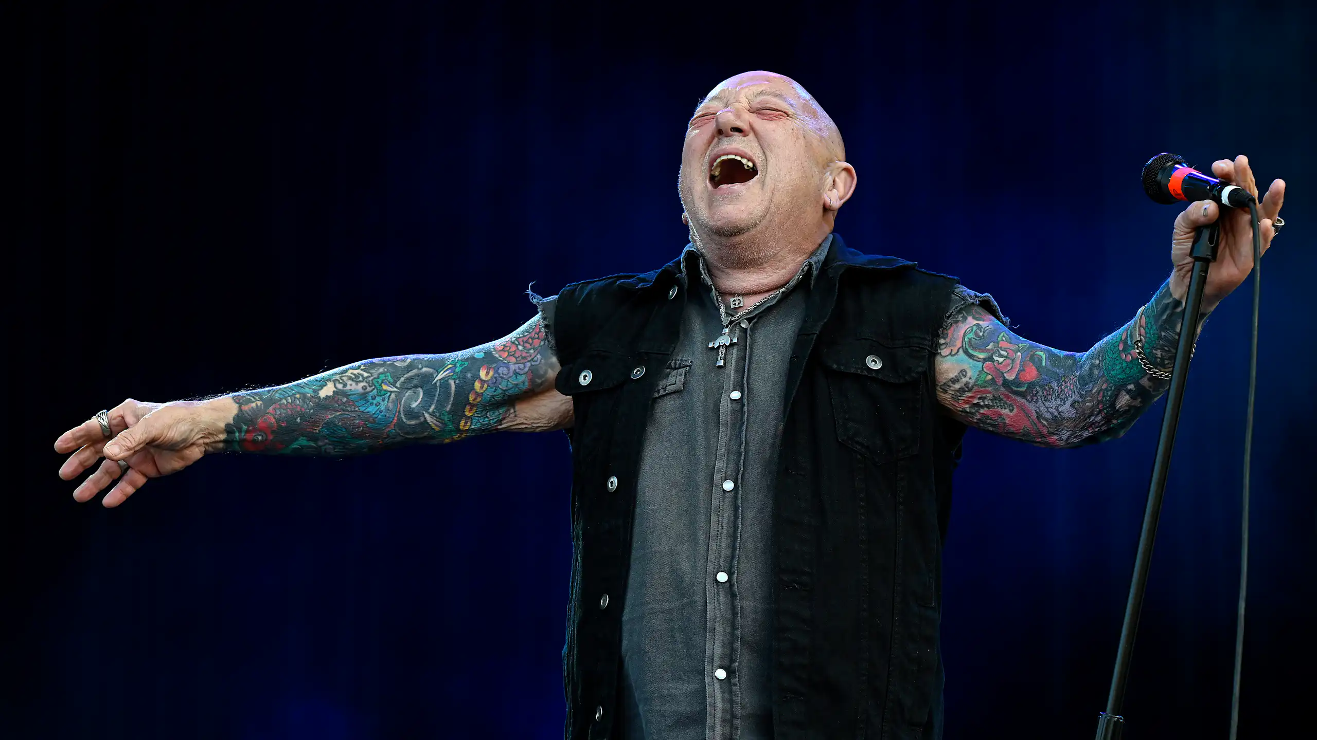 Angry Anderson performs on stage in 2025.