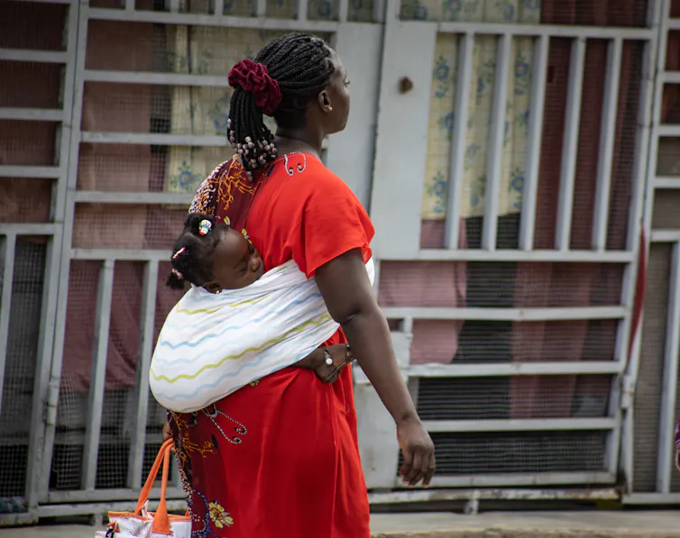 Une mère porte son enfant dans les rues d’Abidjan