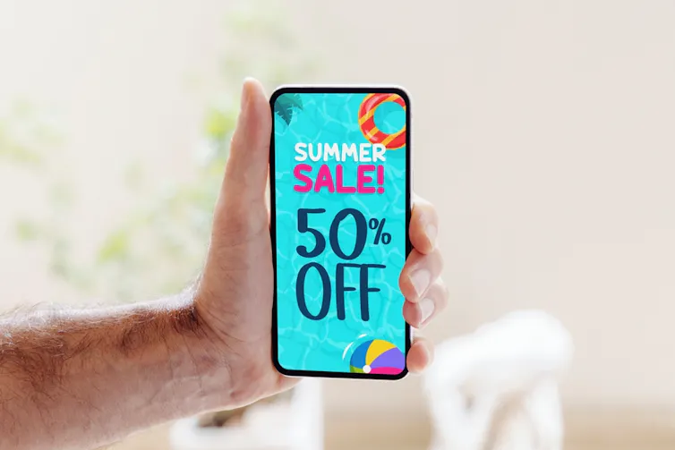 Man holds mobile phone showing special offer image