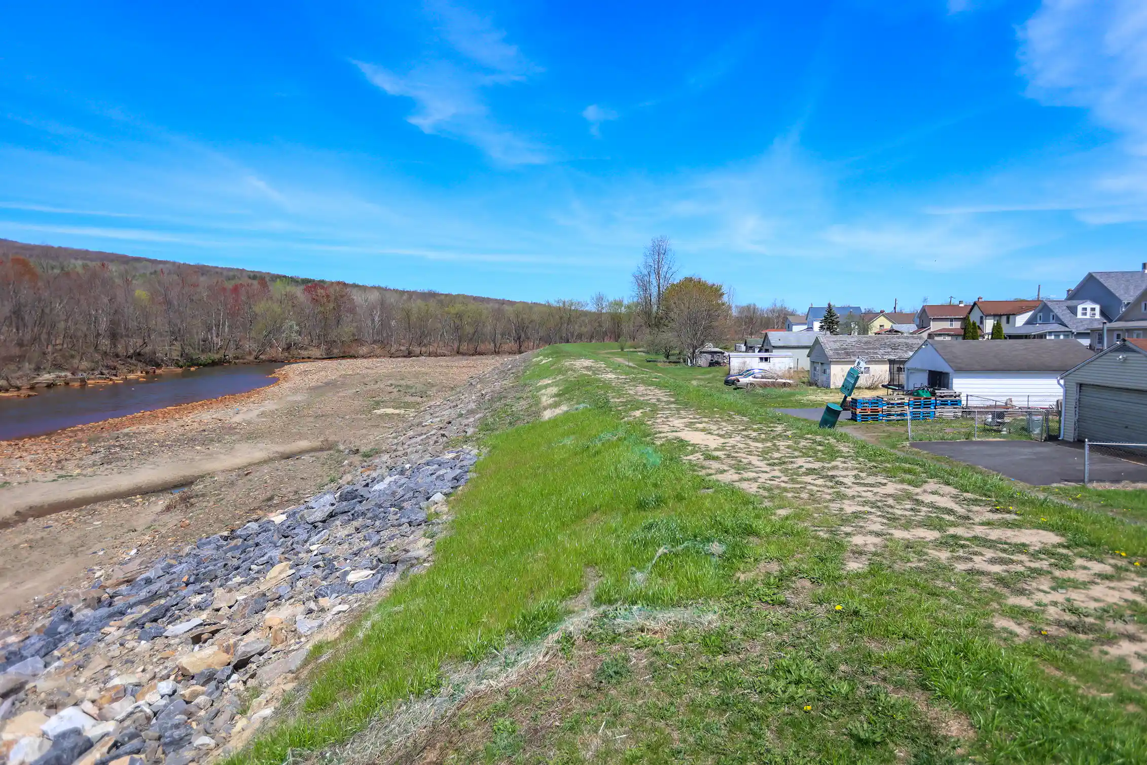 View of small embankment between body of water and houses
