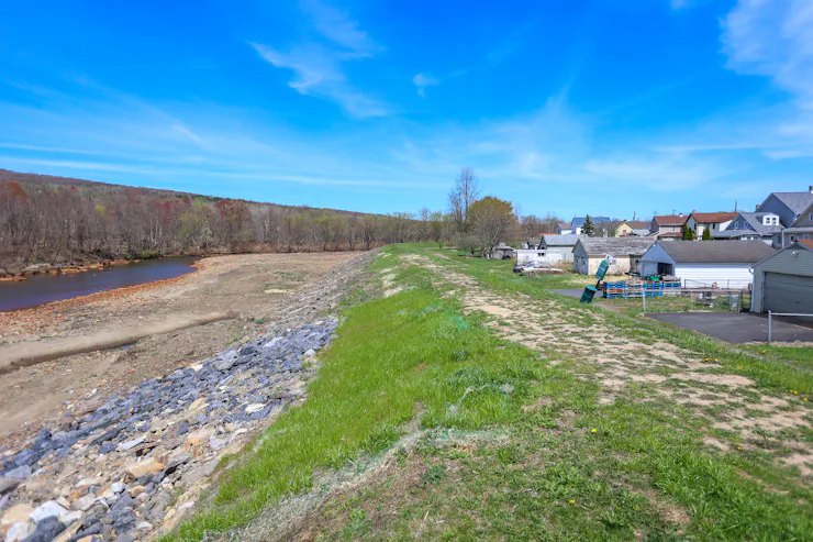 View of small embankment between body of water and houses
