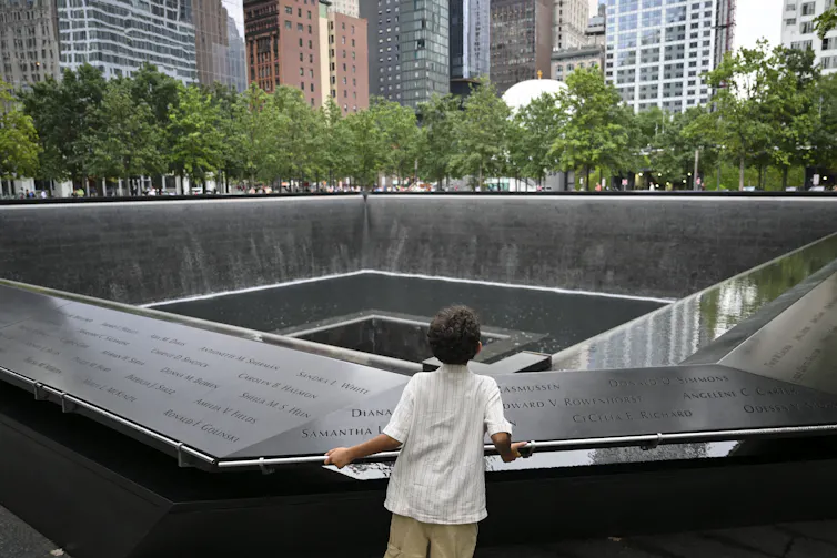 A child looks at the south tower reflecting pool memorial