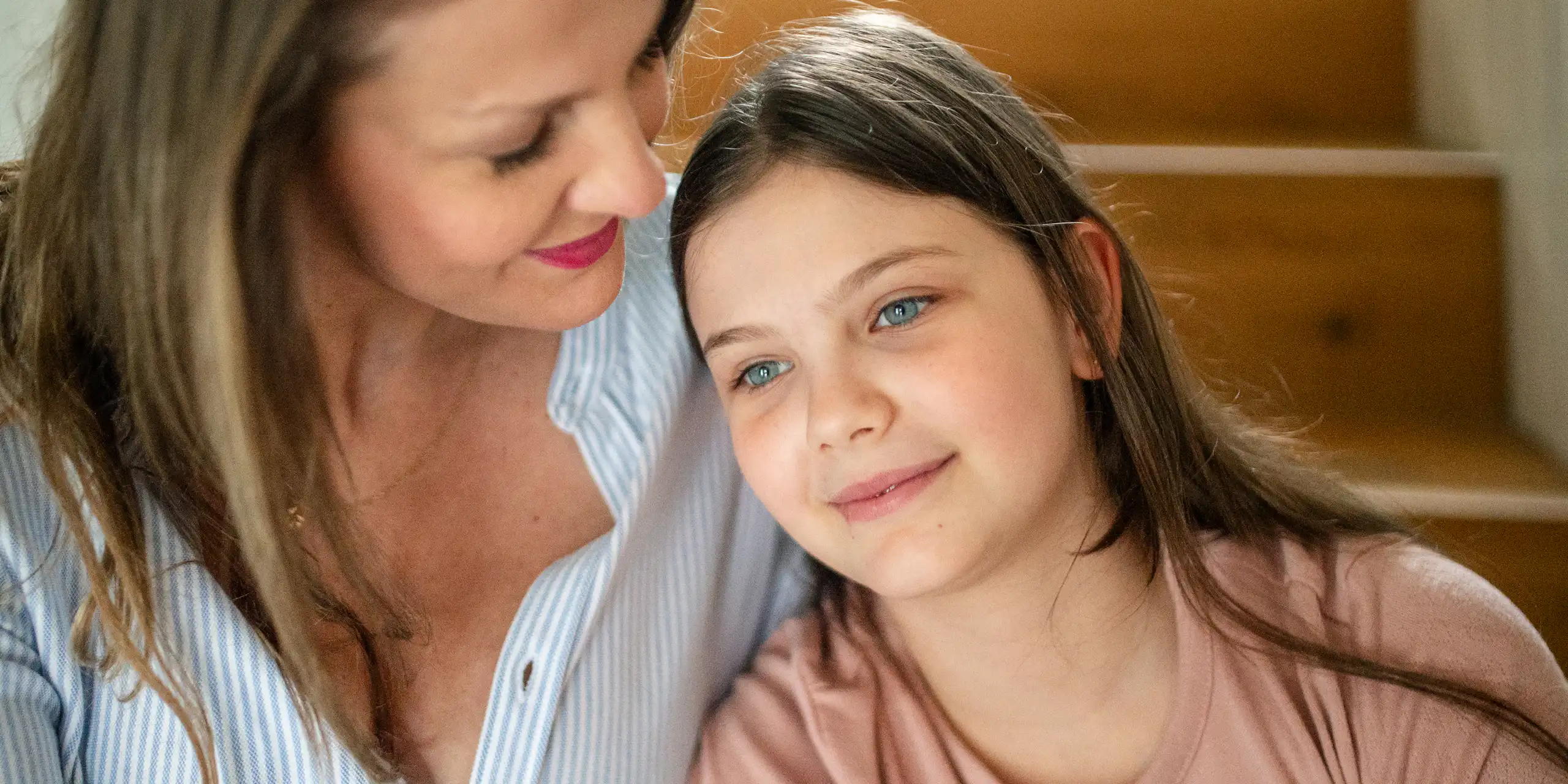 A girl and her mother sit on their stairs
