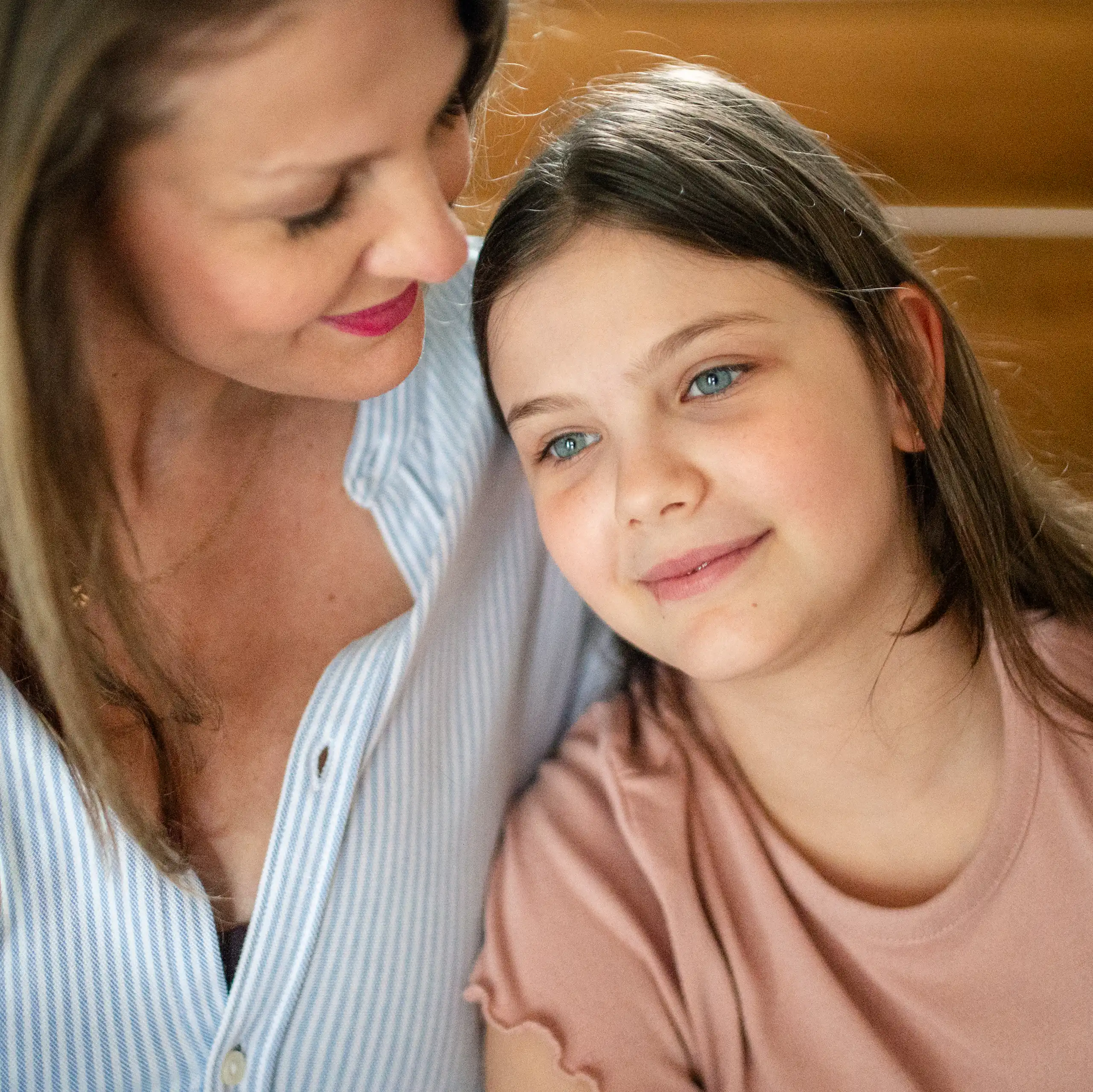 A girl and her mother sit on their stairs
