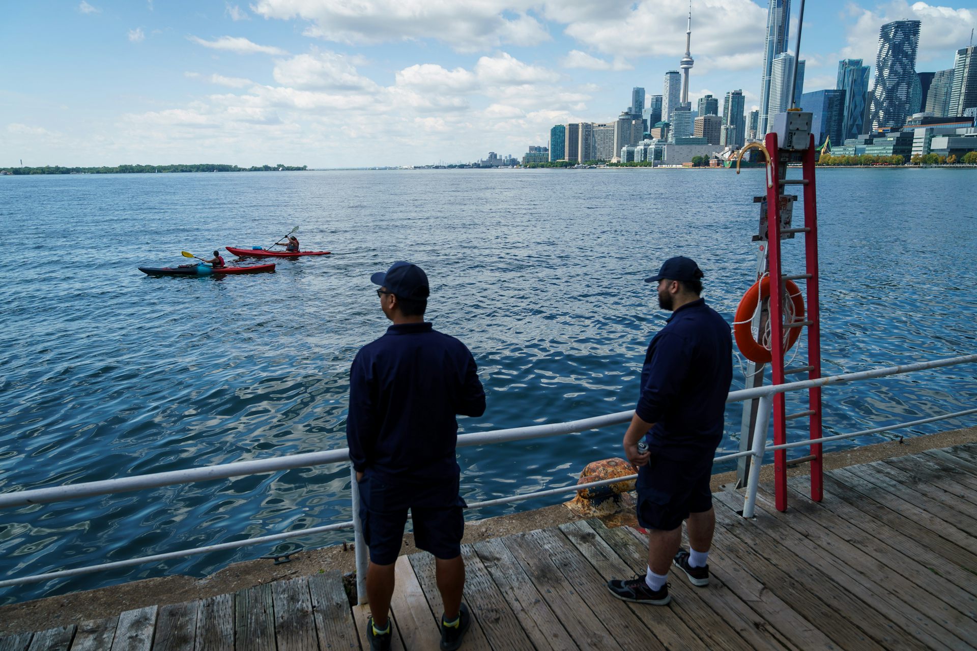 Des gens se tiennent sur la berge du lac Ontario
