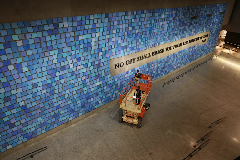 'No Day Shall Erase You From the Memory of Time' is inscribed on a blue tile wall at the 9/11 Memorial Museum.