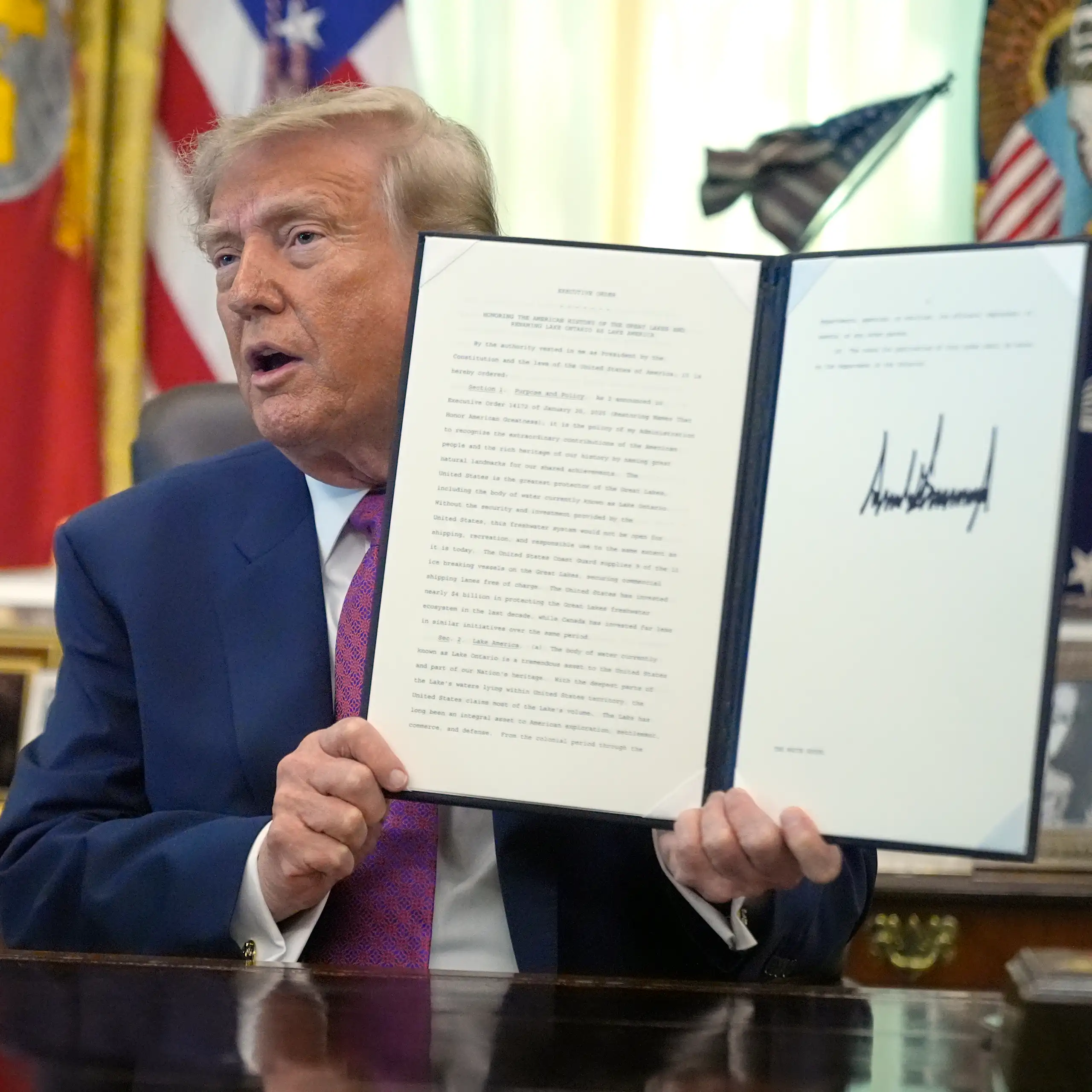 Le président Donald Trump brandit un décret signé dans le Bureau ovale de la Maison-Blanche