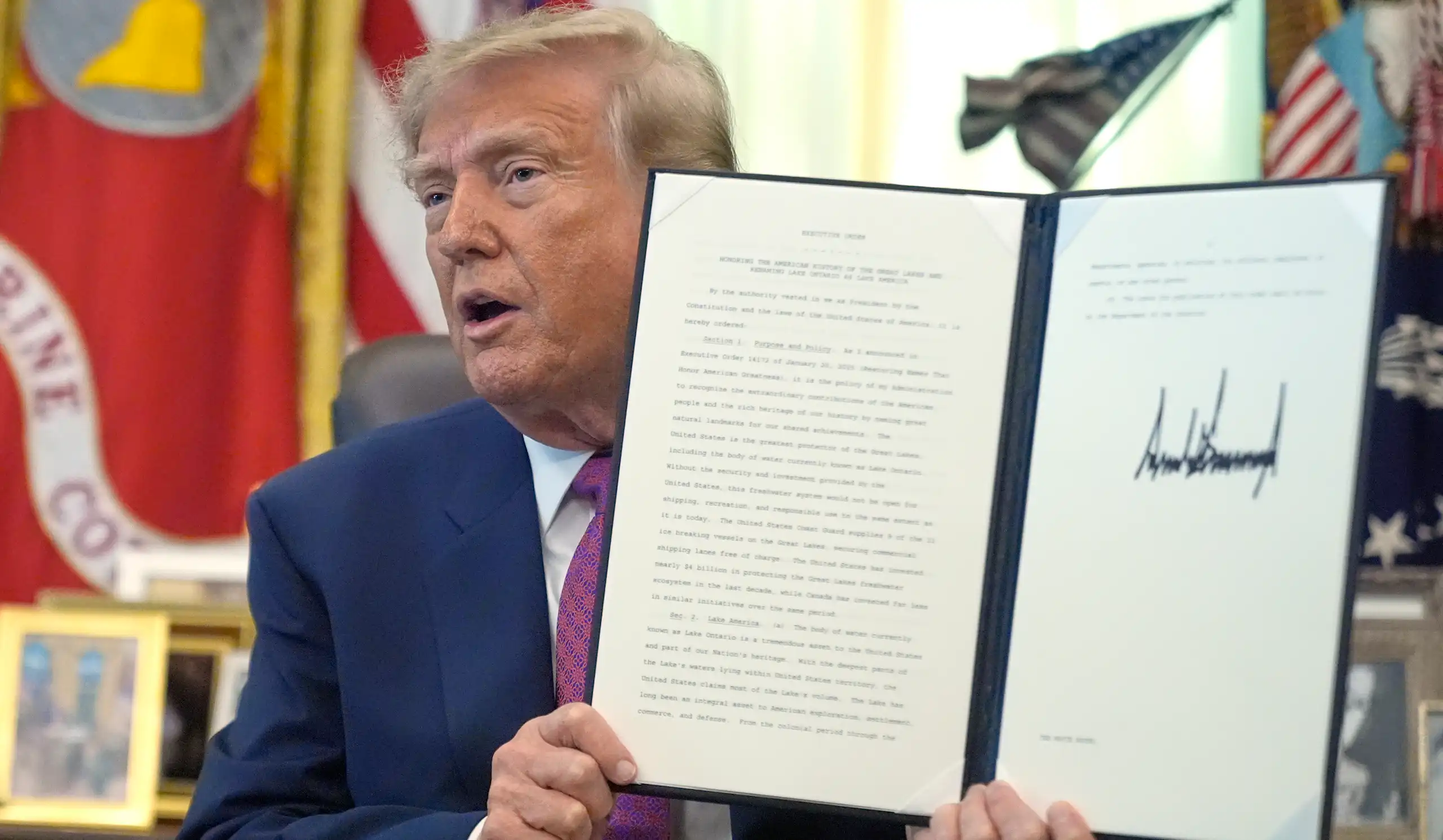 Le président Donald Trump brandit un décret signé dans le Bureau ovale de la Maison-Blanche