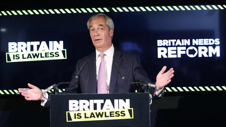 reform uk leader nigel farage at a lectern in front of slogans reading britain is lawless and britain needs reform.