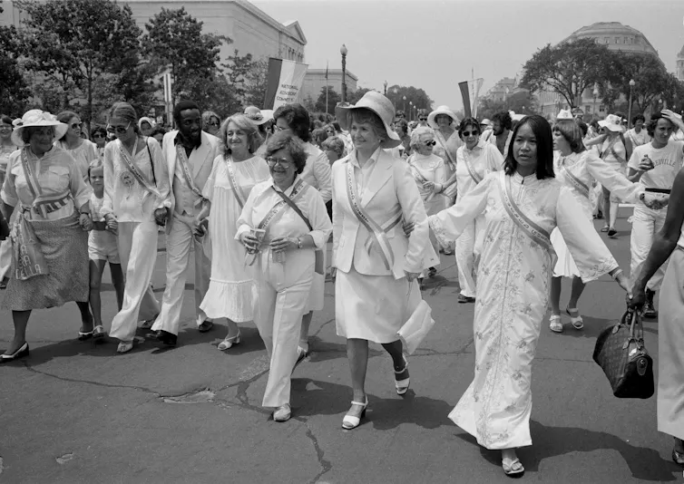 A line of people walk together at a rally.