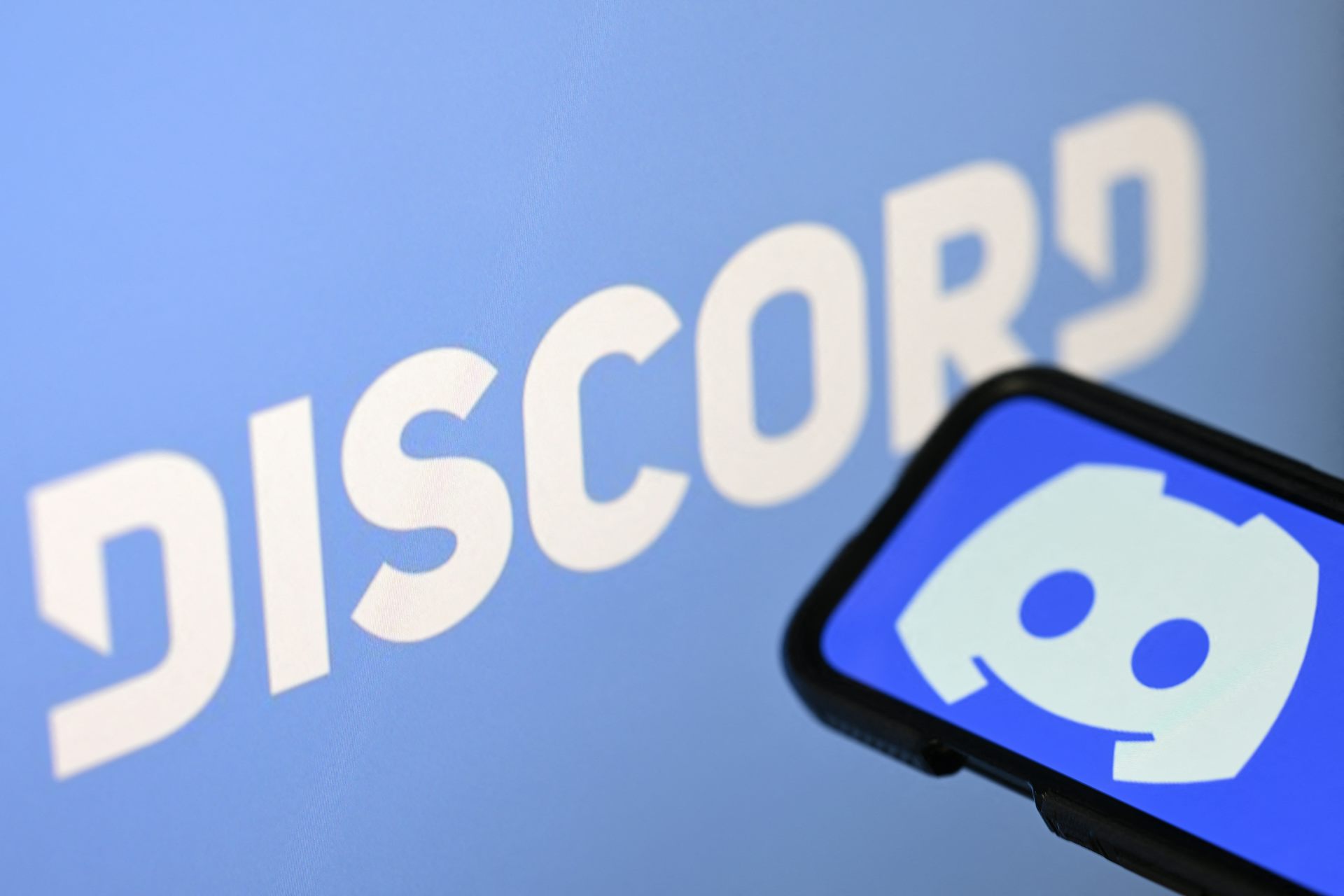 A screen shows an emblem with the word Discord.