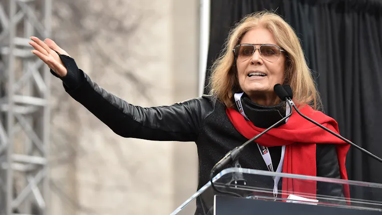 A woman at a protest lectern gives a speech