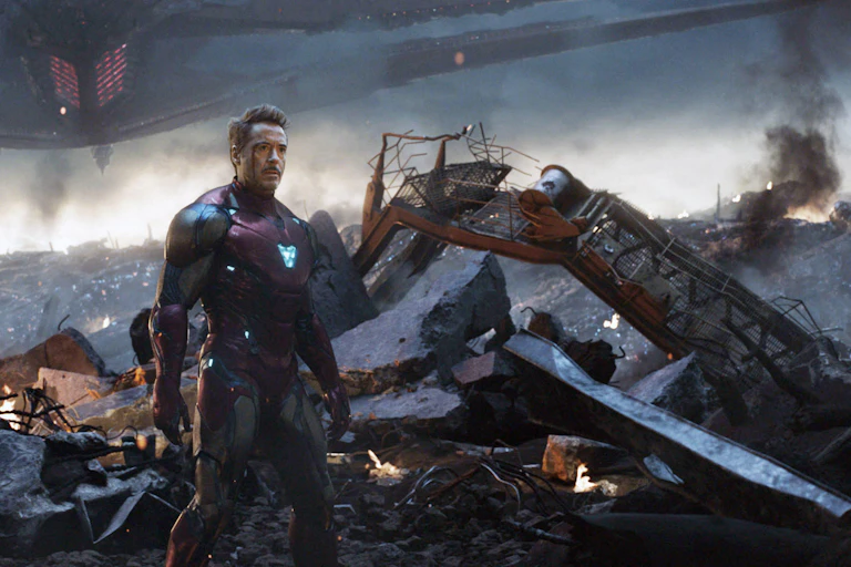 An man with a head injury standing in a desolate apocalyptic landscape beside his crashed space vehicle.